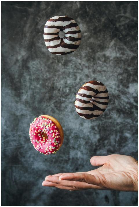 Three donuts with vibrant icing and sprinkles in m