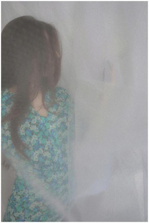 Artistic portrait of a woman in a floral dress beh