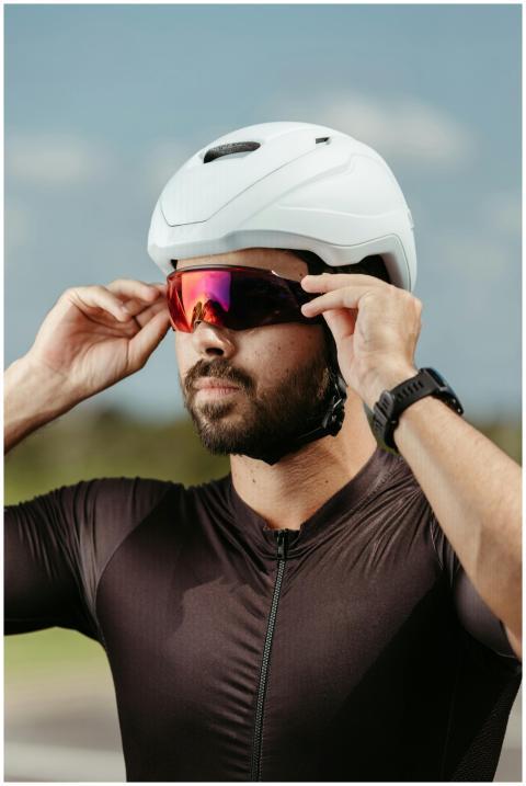 Male cyclist adjusts sunglasses while wearing a wh