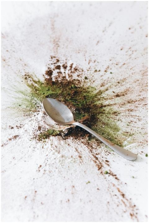 A spoon surrounded by a colorful burst of spices o