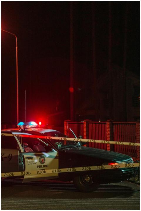 A police car with flashing lights at a nighttime c