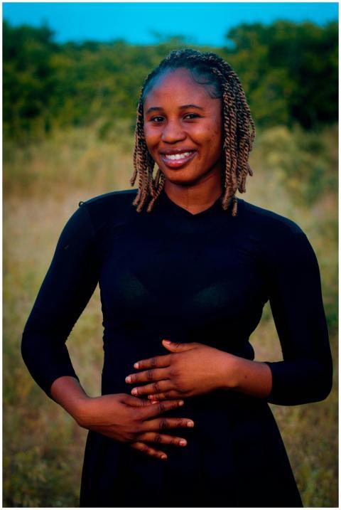 A young woman smiling and posing confidently in an