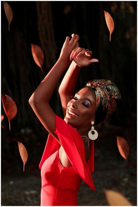 Joyful woman dancing outdoors, surrounded by falli