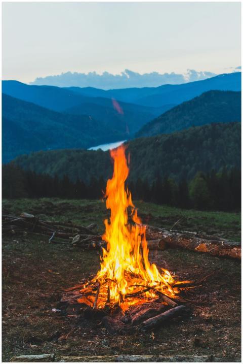 A serene campfire with a stunning mountain backdro