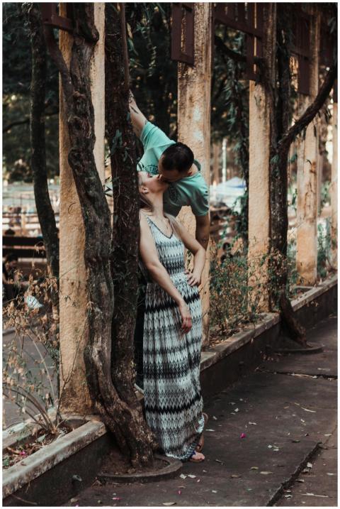 A couple shares a tender kiss in an urban park set