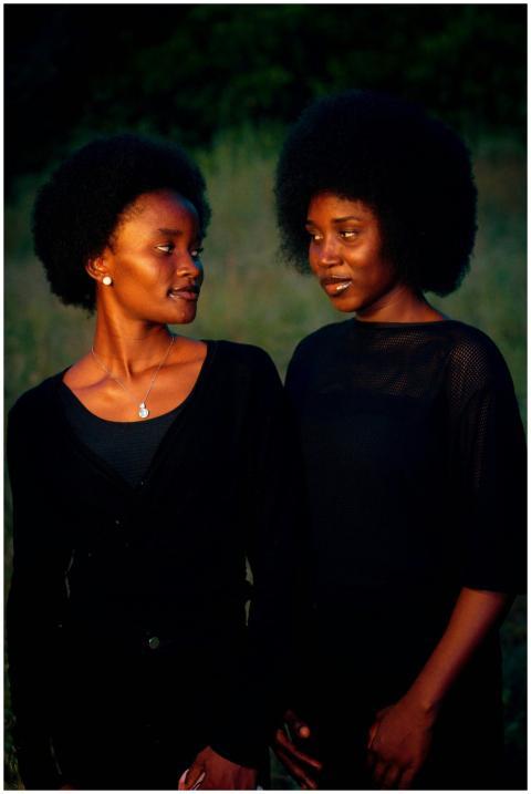 Two women outdoors with afros, capturing warmth an