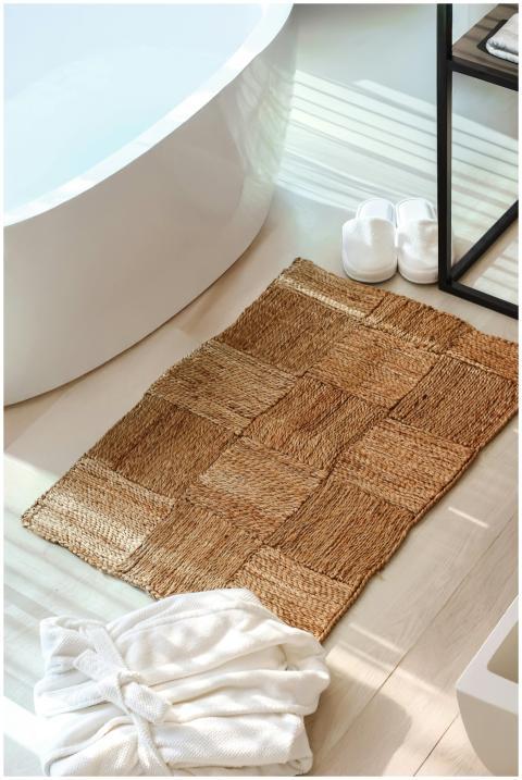 Bright bathroom setting featuring woven mat, batht