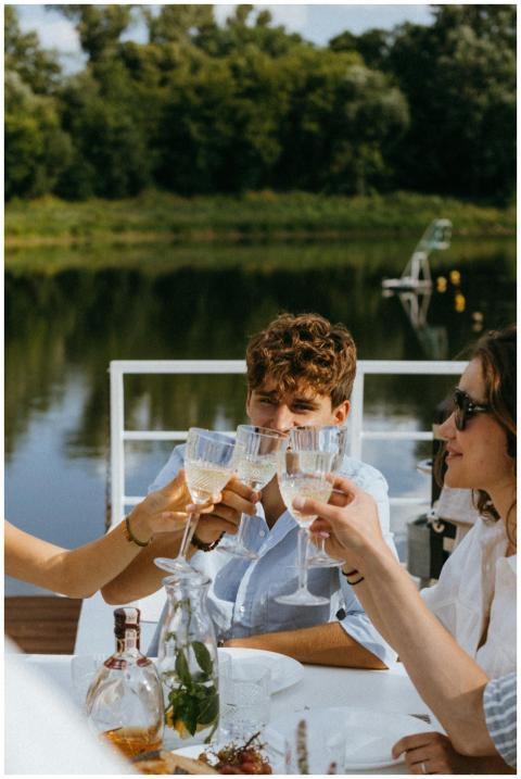 Group of friends enjoy an outdoor toast by the lak