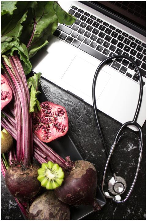 Flat lay of fresh vegetables, fruits, stethoscope,
