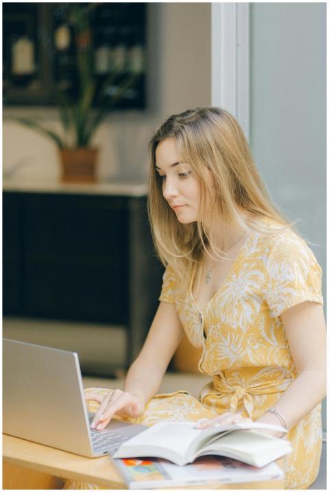 Young woman in a yellow dress working on a laptop