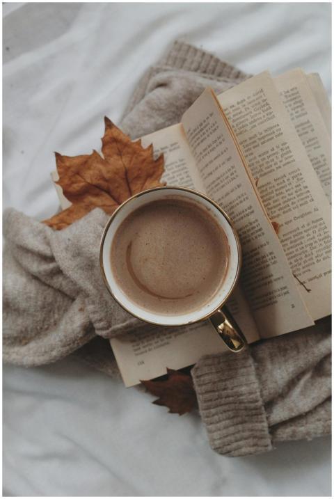 Enjoy a warm coffee with a book and autumn leaves