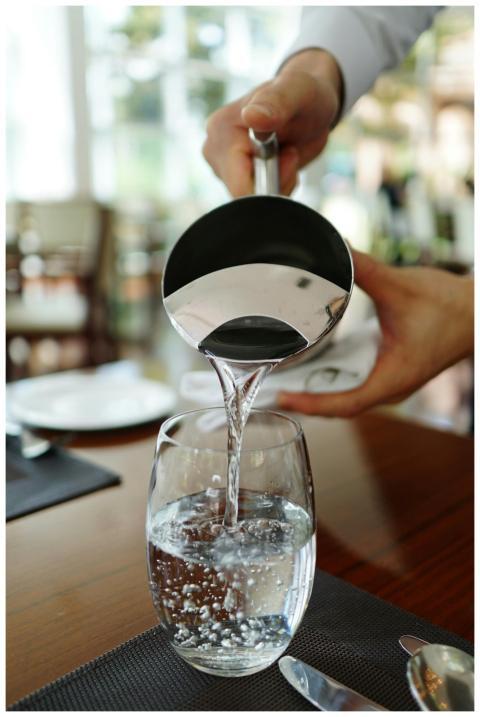 Close-up of water being poured into a glass in a r