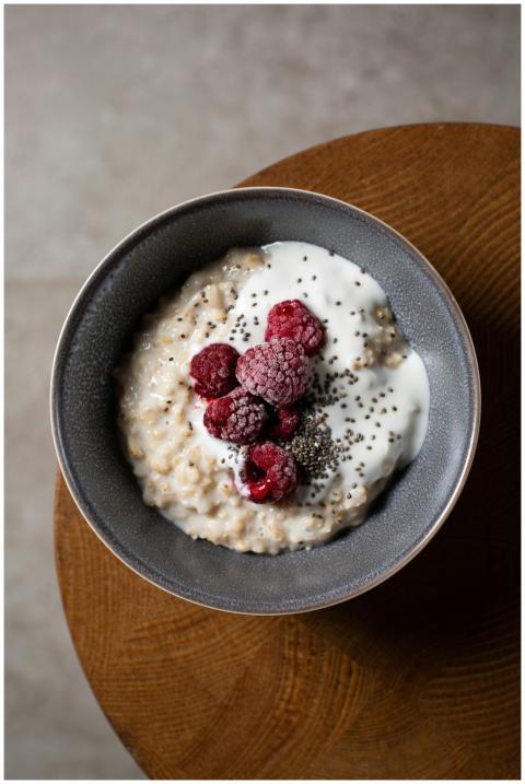 Delicious bowl of oatmeal with raspberries, yogurt