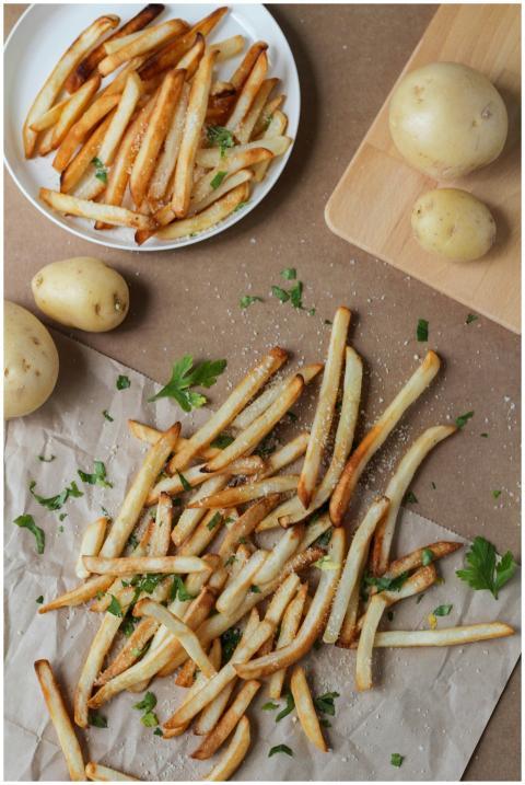 Crispy golden French fries seasoned with herbs, pe