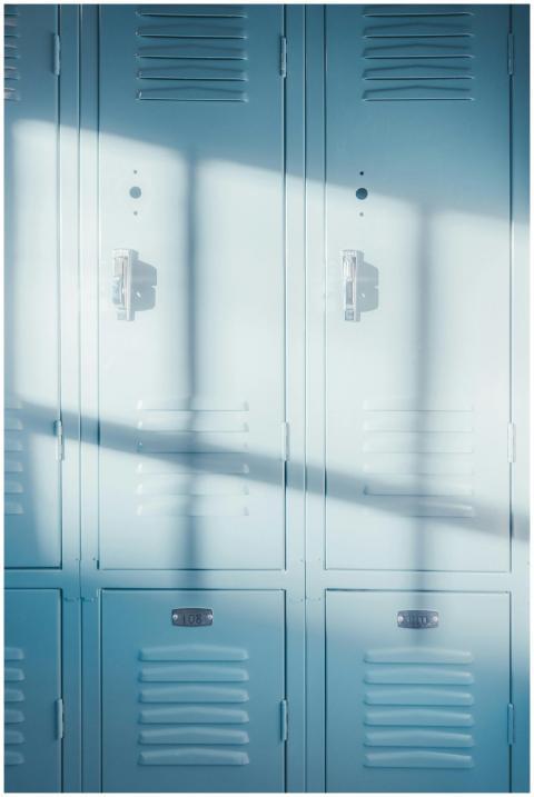 A row of bright blue school lockers illuminated by
