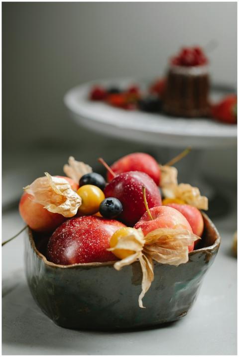 Appetizing fresh berries and apples in a ceramic b