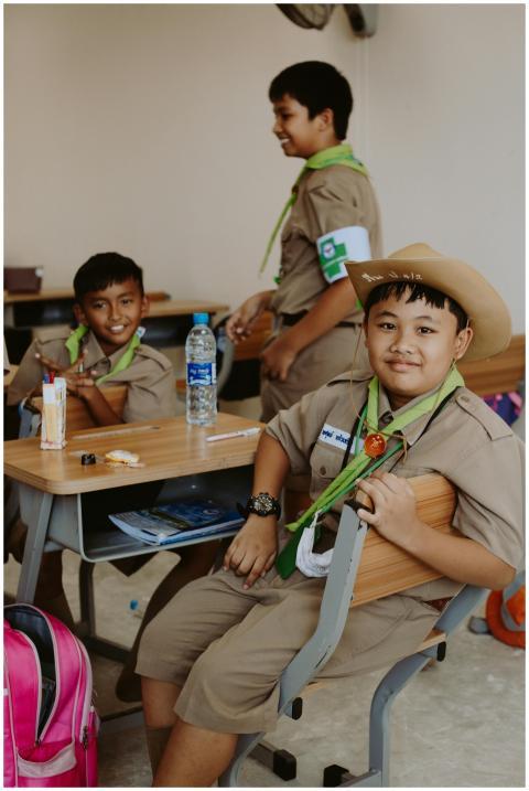 Group of boy scouts smiling in a classroom wearing