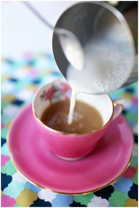 A vibrant image of milk being poured into a pink c