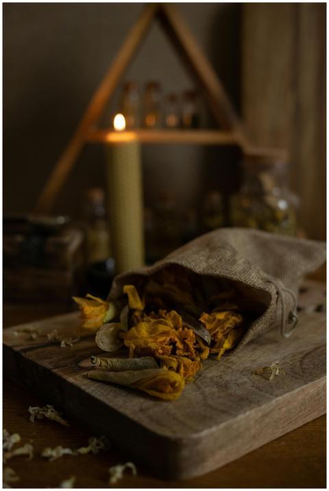 A rustic setup with dried herbs in a sack and a gl