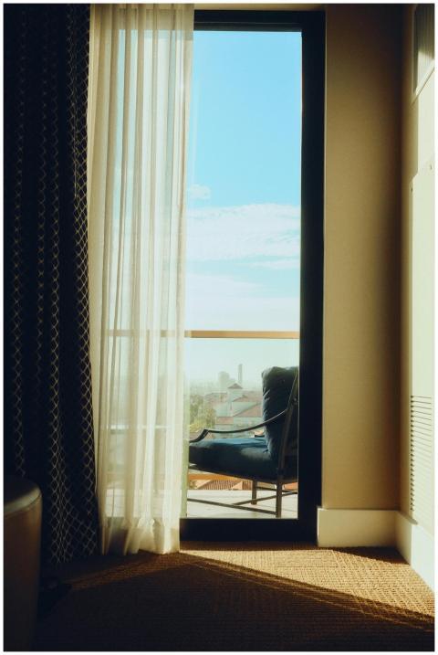 A serene hotel room with elegant sheer curtains op