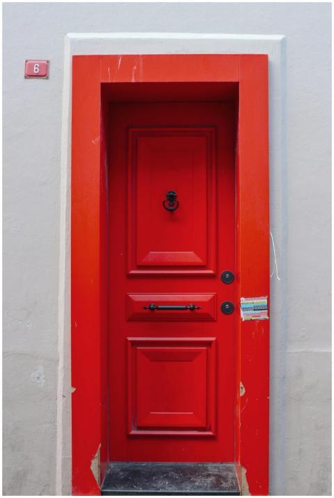 A striking red door set against a contrasting whit
