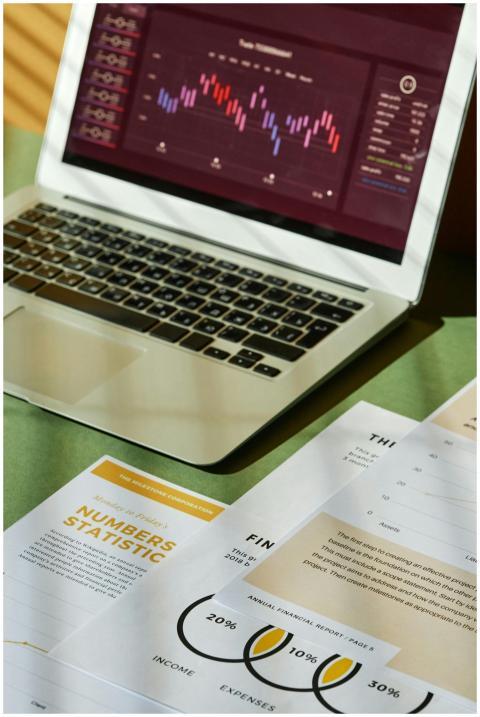 Close-up of financial documents and a laptop displ