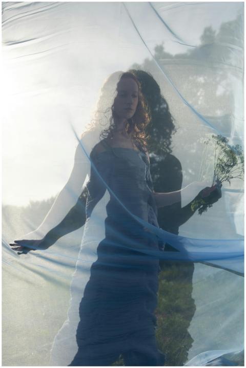 Ethereal concept of a woman in a blue dress holdin