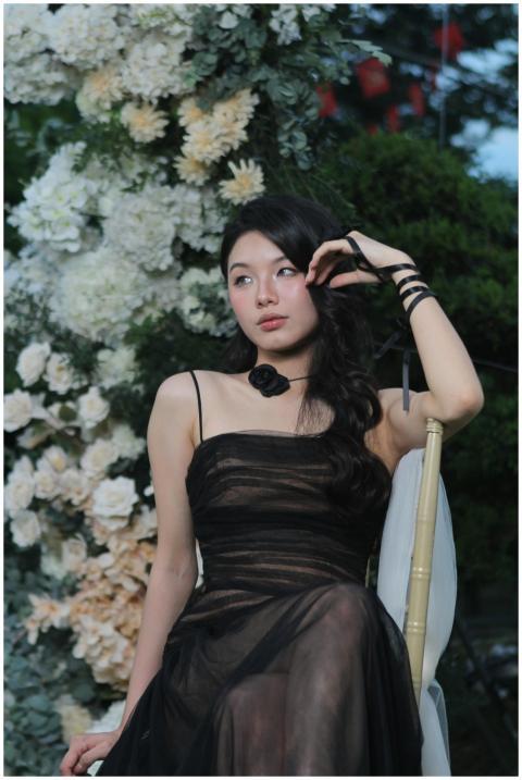 A serene portrait of a woman in a black dress surr