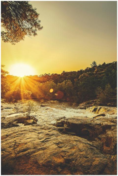Stunning sunset over a rocky river surrounded by l