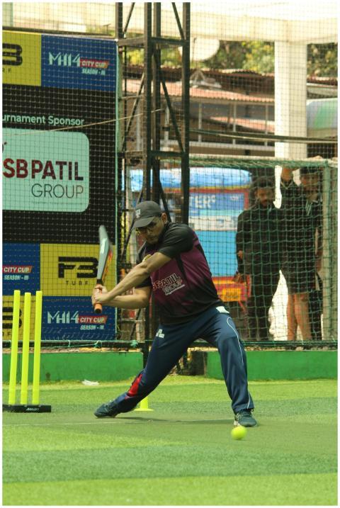 Cricketer in action swinging bat on an outdoor tur