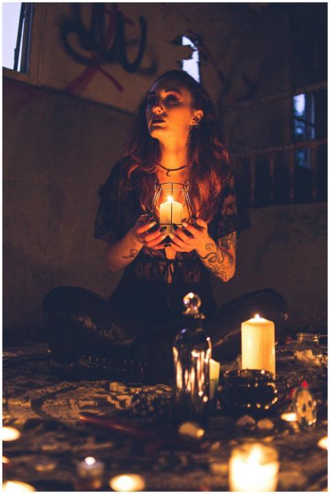 A mysterious woman engages in a ritual, holding a