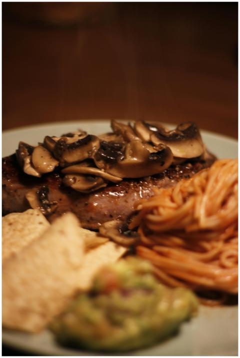 A delicious steak topped with mushrooms, served wi