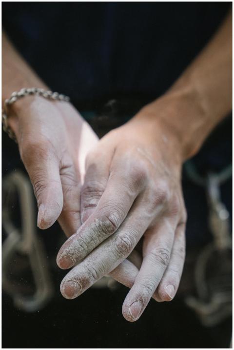 Detailed close-up of hands covered in chalk before