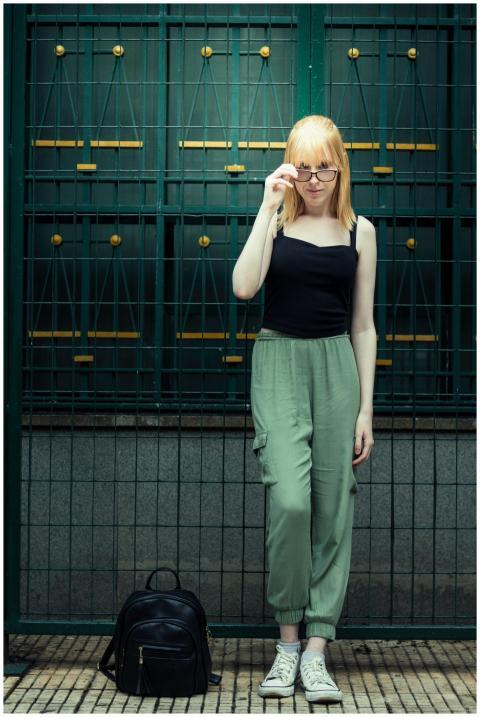 Trendy young woman with eyeglasses posing by a met