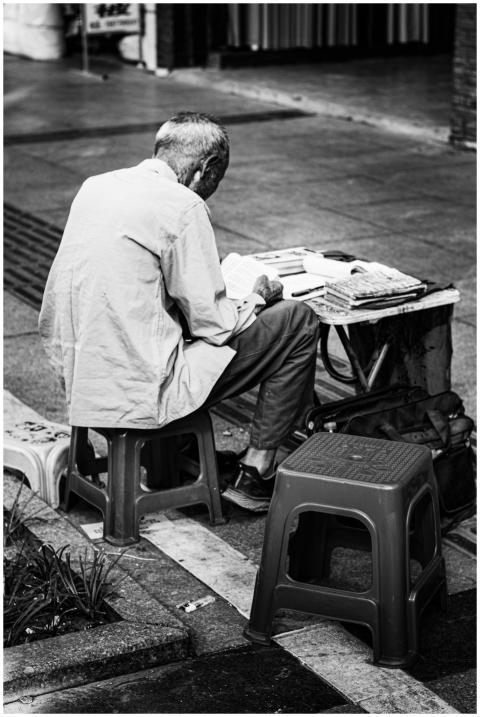 Black and white photo of a senior man reading on a