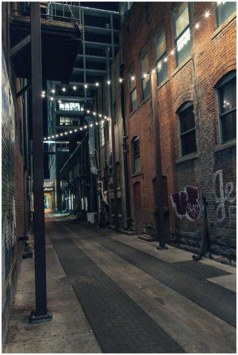 Cozy urban alley illuminated by string lights, sho