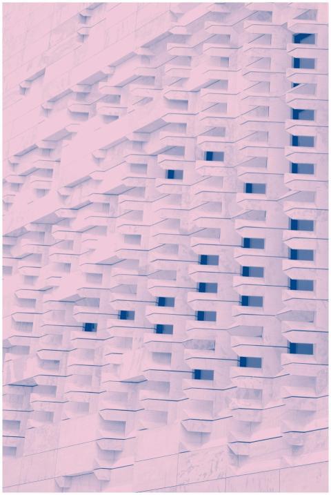 Abstract pink-toned facade with geometric shapes a