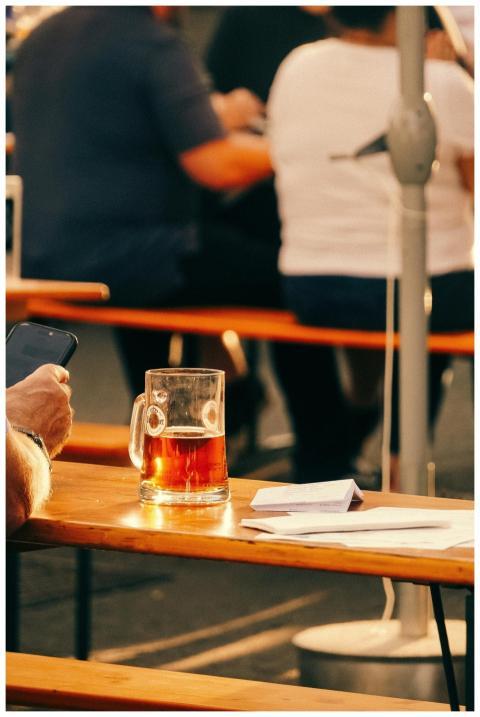 A sunlit beer garden with people enjoying drinks a