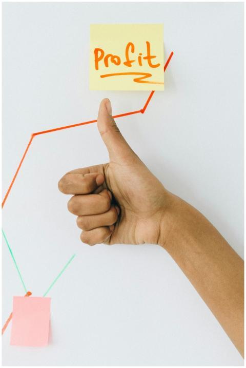 A hand giving a thumbs up in front of a profit gro