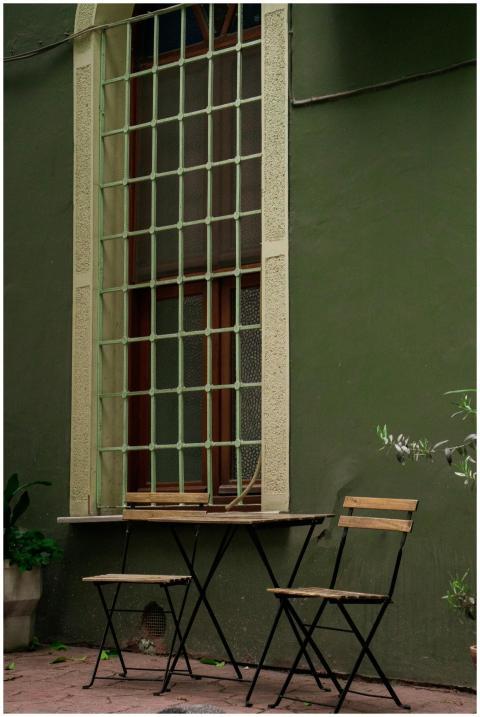 Elegant windows with outdoor chairs against a gree