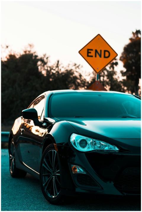 Stylish black luxury car parked near a road end si