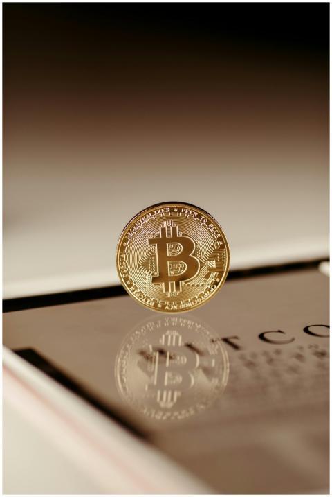Gold Bitcoin reflecting on a digital tablet screen