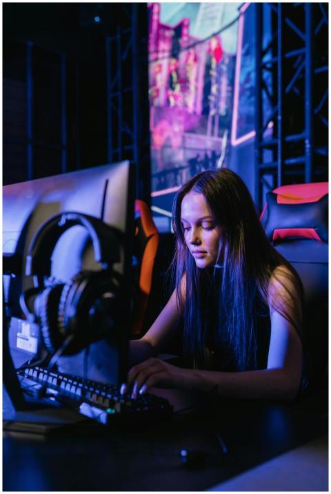 Woman immersed in gaming on a computer with headph