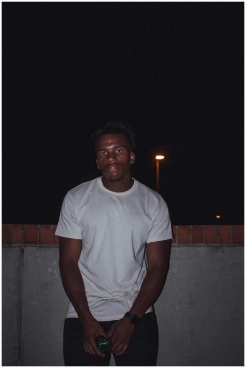 A portrait of a young man in a white shirt posing