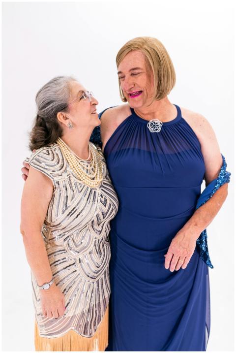 Two senior women dressed elegantly, smiling and em