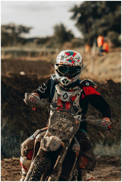 A motocross rider speeding on a dirt track, showca