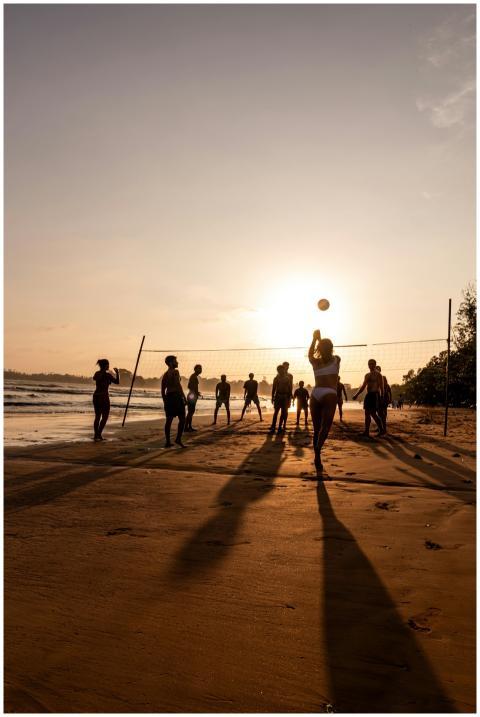 Group playing beach volleyball during a stunning s