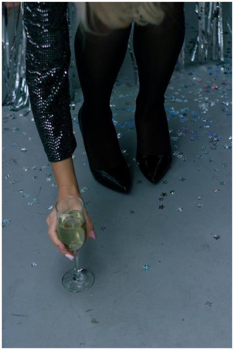 Close-up of a woman in black heels picking up a ch