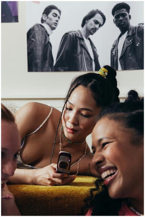 Teenage girls relaxing indoors with a mobile phone