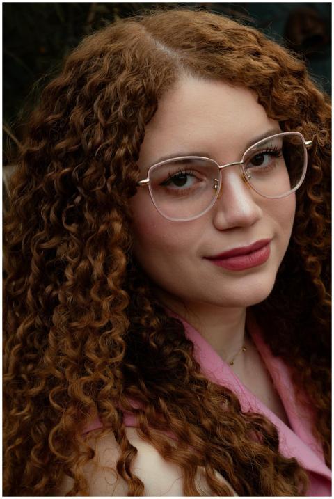 Close-up portrait of a woman with curly hair and g